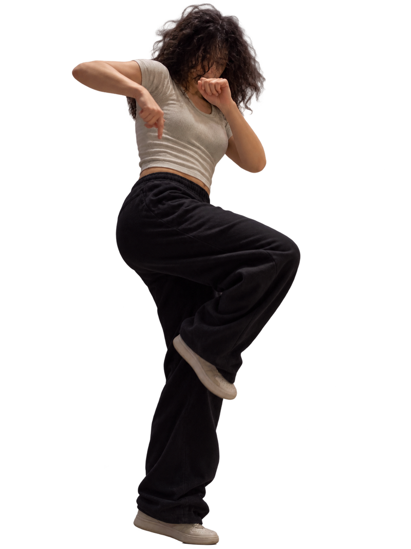 Una persona in un movimento di danza libera ed espressiva, con gamba sollevata.
